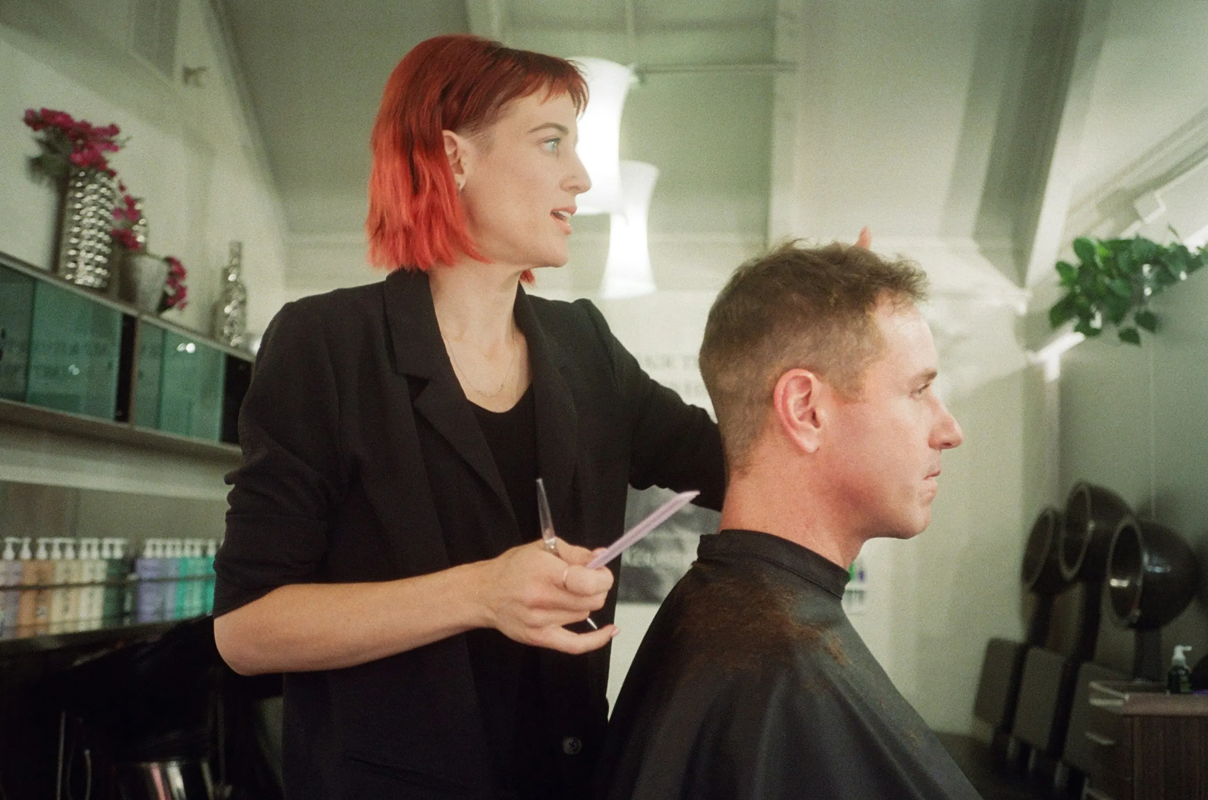 A hairstylist and client mid-conversation during a haircut